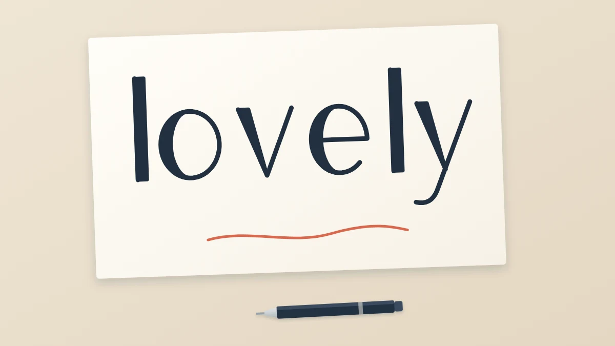 The word lovely in filled faux calligraphy with thick downstrokes on a sheet of paper next to an ordinary fineliner pen